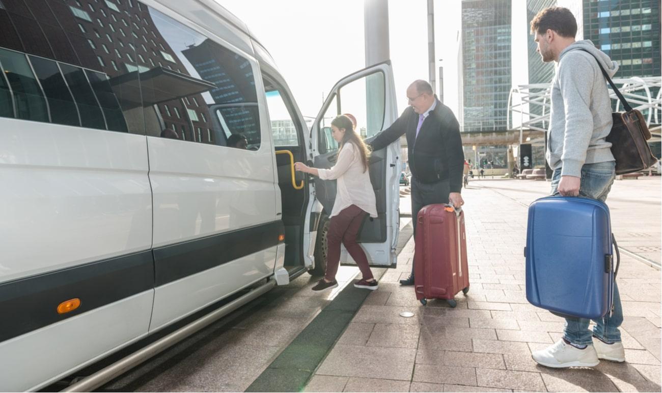 três pessoas carregando malas de viagem usando o serviço de shuttle