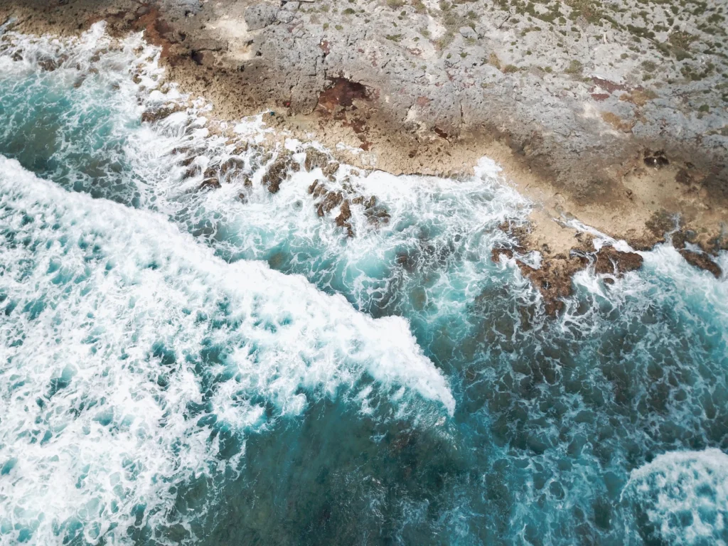 Foto de Akumal, una de las mejores playas de México, con las del océano golpeando la tierra durante el día