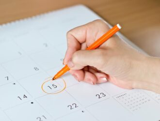 mão feminina circulando o número 15 em um calendário