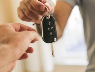 man handing car keys to another person