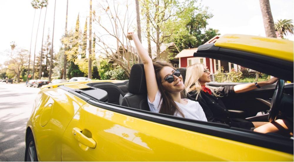 jovens em carro conversível