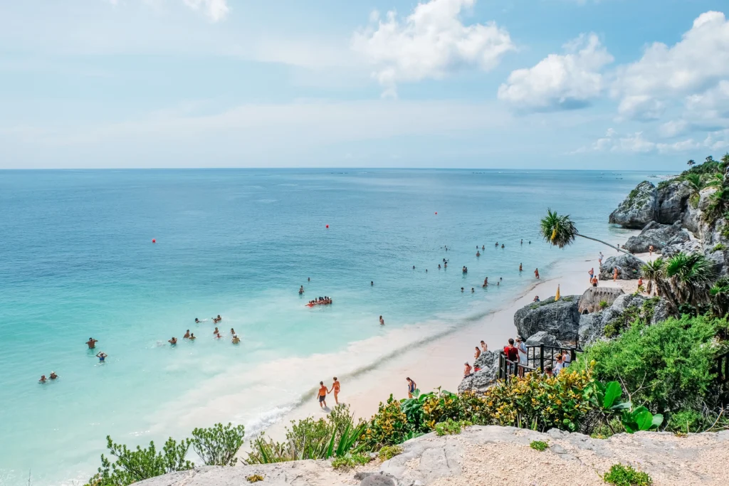 Foto de paisaje de playa en Tulum, con arena blanca y aguas turquesa.
