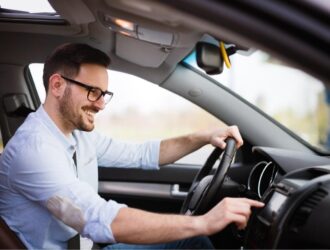man smiling driving a car