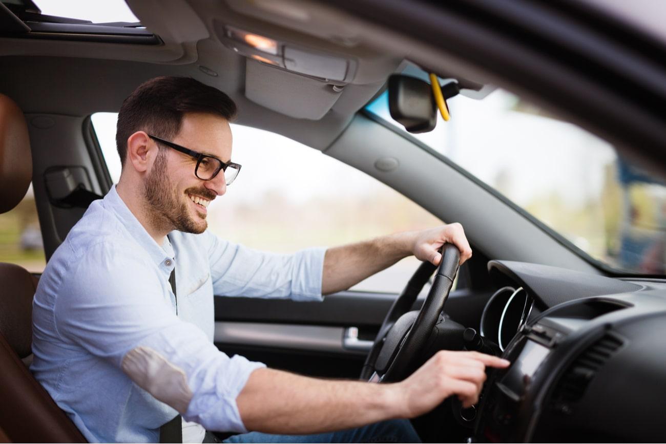 man smiling driving a car