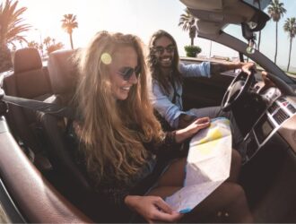 casal em carro conversível durante dia ensolarado