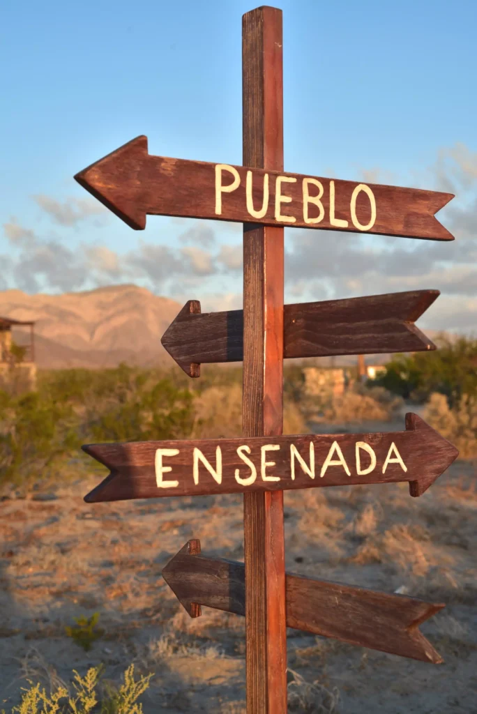 Letrero indicando las ciudades de Pueblo y Ensenada en México