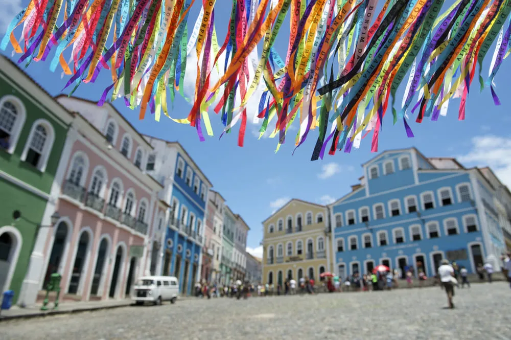 A foto é do Pelourinho, com construções antigas, no centro histórico de Salvador, além de fitinhas do Senhor do Bonfim.