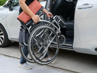 Person putting a wheelchair inside a vehicle.