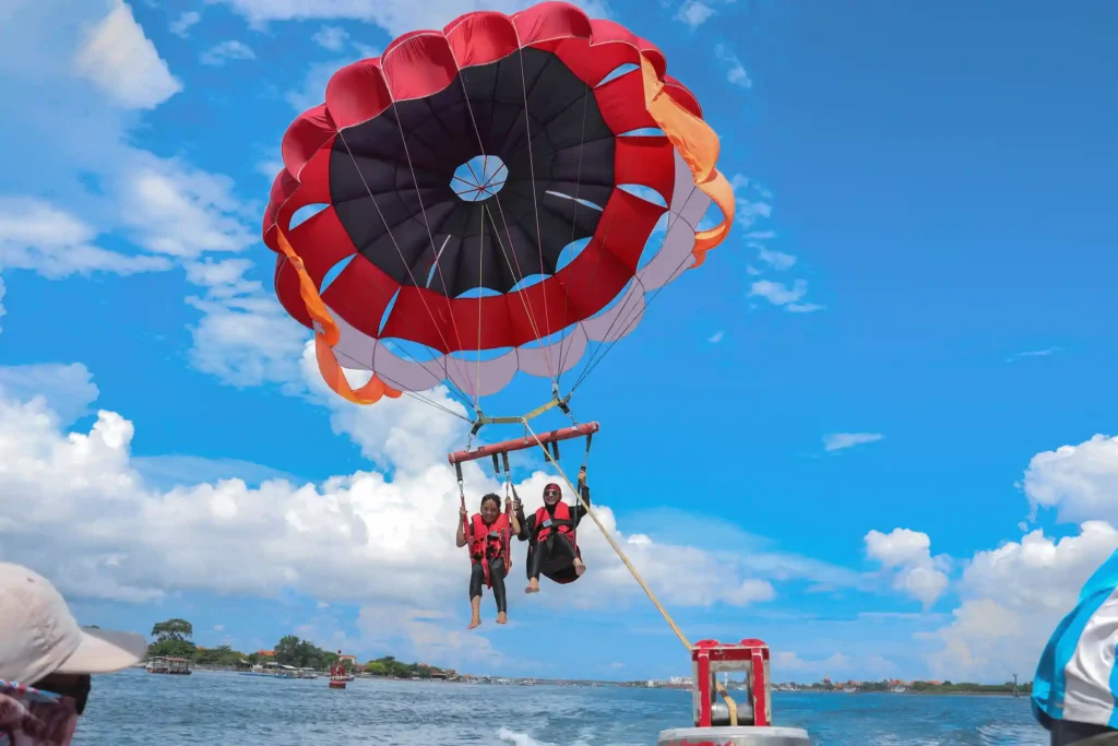 Pareja haciendo parasailing empujados por una lancha