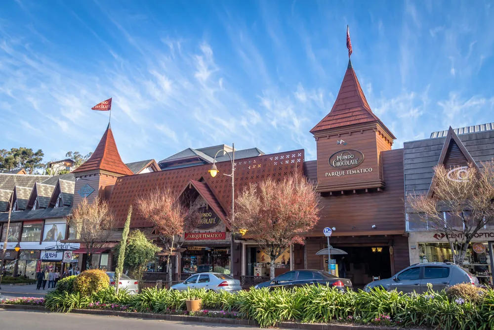 Foto dos comércios em formato de castelo da cidade de Gramado, no Rio Grande do Sul. O céu está azul.