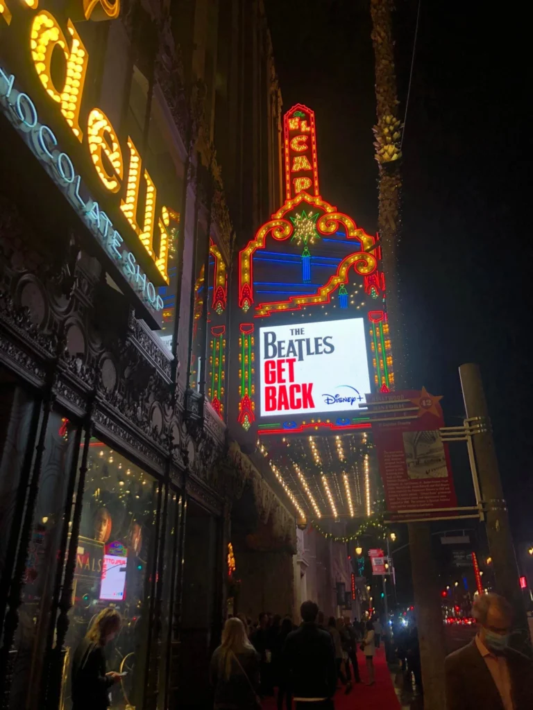 Foto da Calçada da Fama à noite, com as luzes das atrações ligadas e super coloridas. É possível ver um red carpet no chão.
