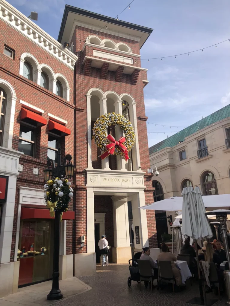 Foto do The Groove, em Beverly Hills, é um shopping a céu aberto com lojas e restaurantes. O céu está bem claro e a decoração é de natal.