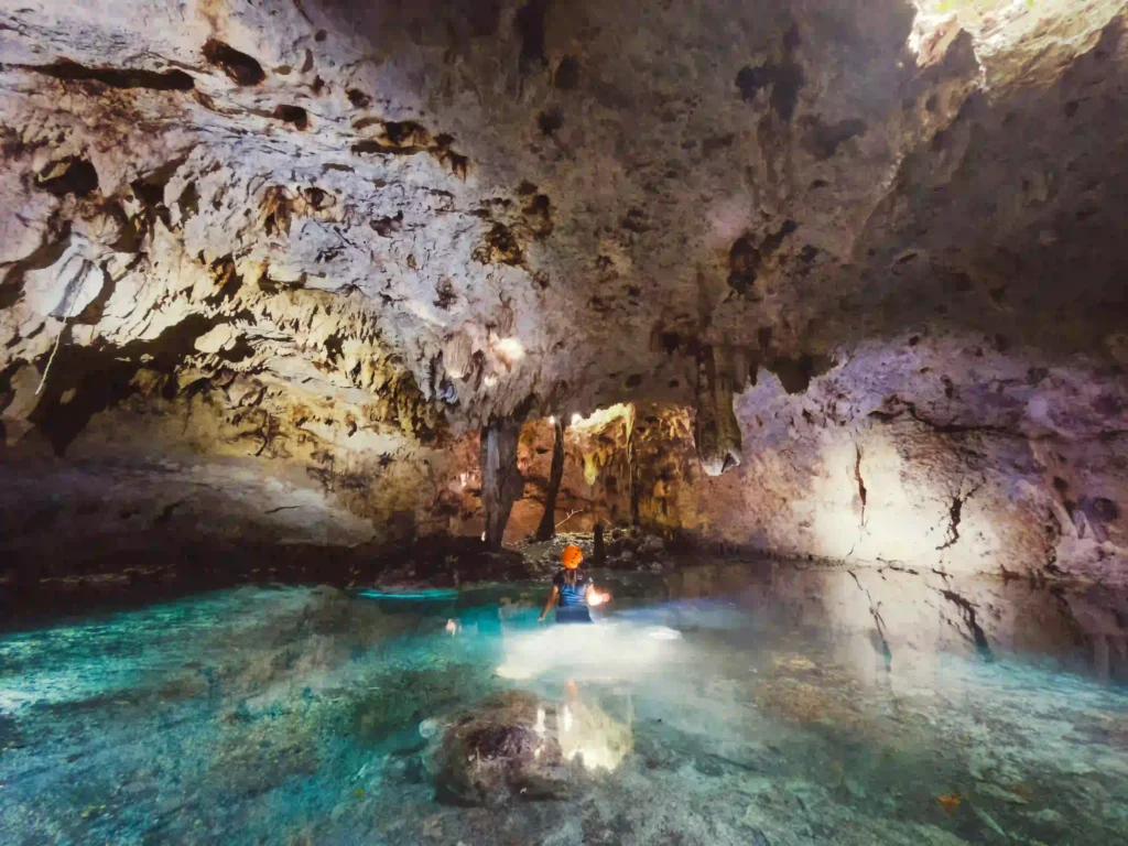Vista de un cenote por dentro con una persona dentro