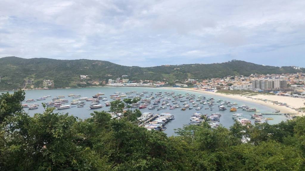 Foto da Praia dos Anjos em Arraial do Cabo. É possível ver uma infinidade de embarcações estacionadas no mar.
