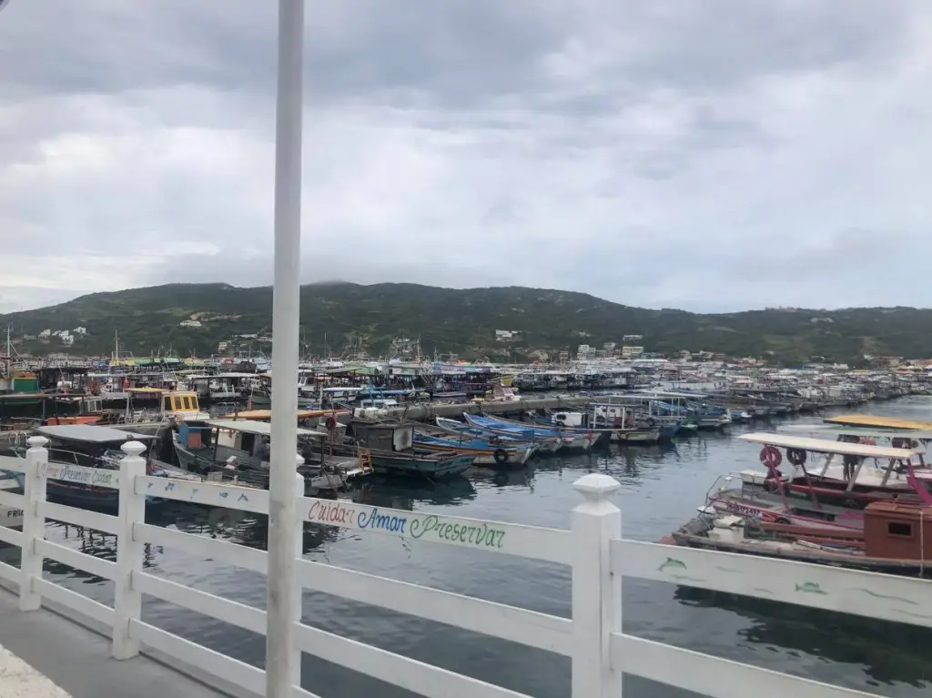 Foto da Praia dos Anjos em Arraial do Cabo. É possível ver uma infinidade de embarcações estacionadas no mar.