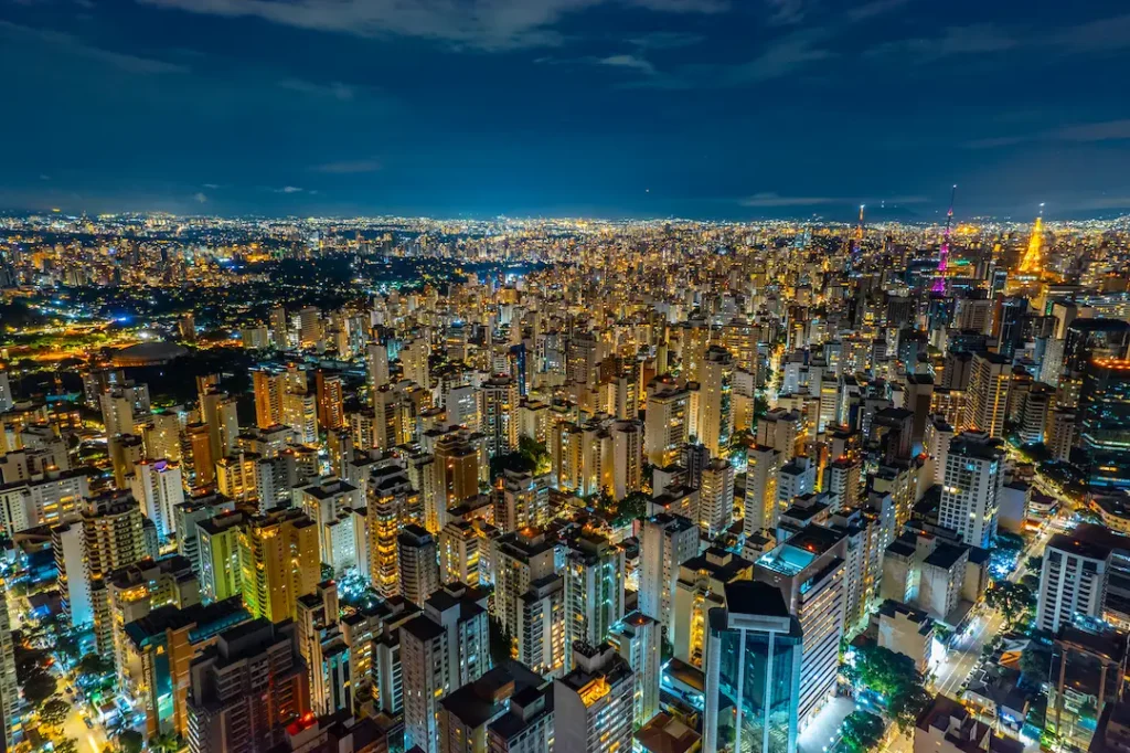 Vista aérea da cidade de São Paulo a noite, com muitos prédios e ruas iluminadas