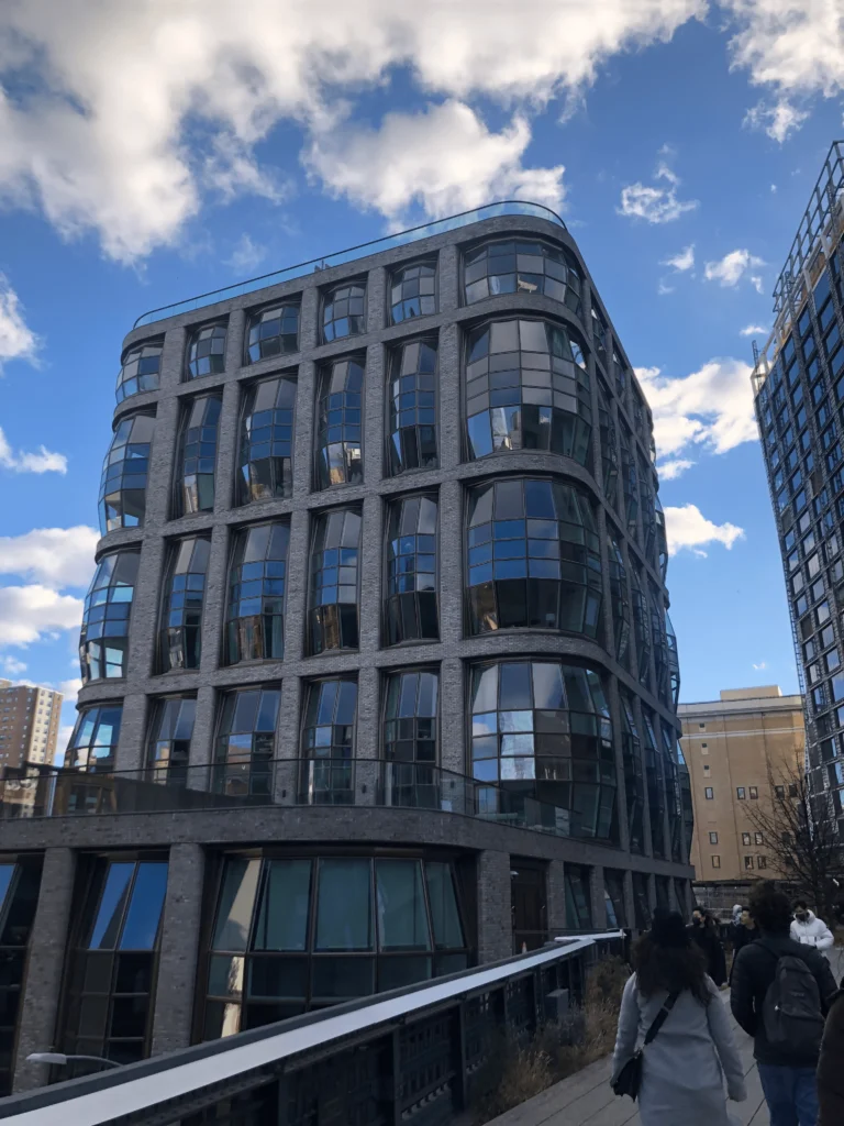 Foto de um dos prédios imponentes do High Line em New York. O prédio é moderno, com vidros em todos os andares em formato oval.