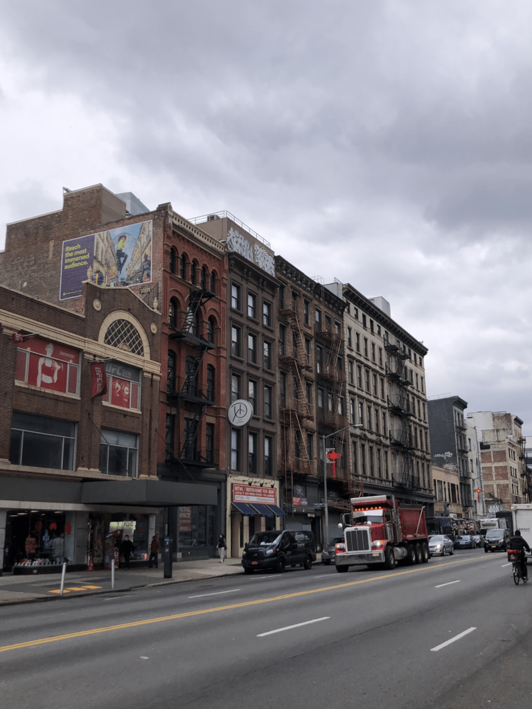 Foto cotidiana de uma das ruas do Soho, bairro nobre de New York. Os prédios são bem característicos da cidade, com as escadas de emergência na parte de fora e seus 4 andares.