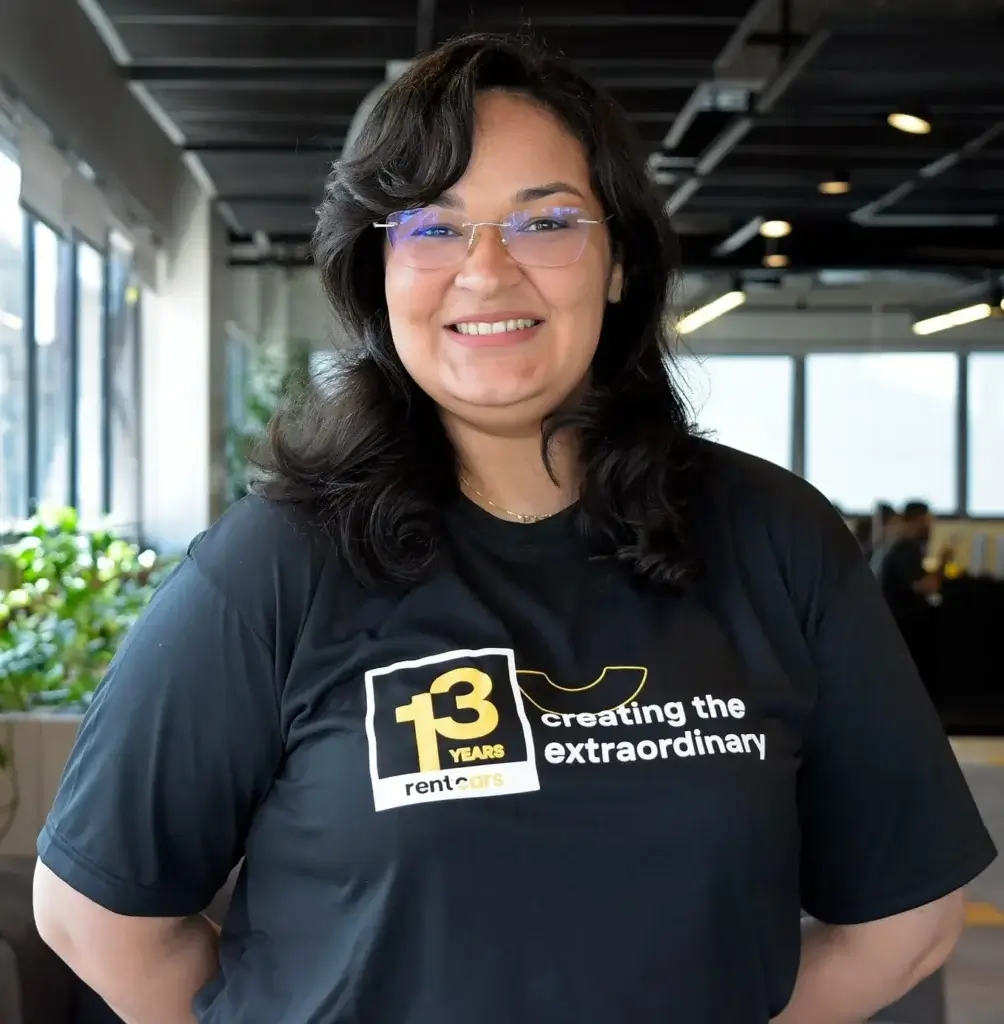 Foto de mujer de pello negro, gafas y la camisa de Rentcars.