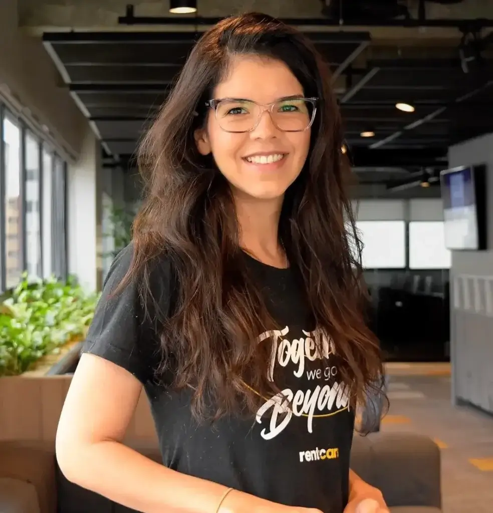 Foto de mujer de gafas y camisa de Rentcars sonriendo.