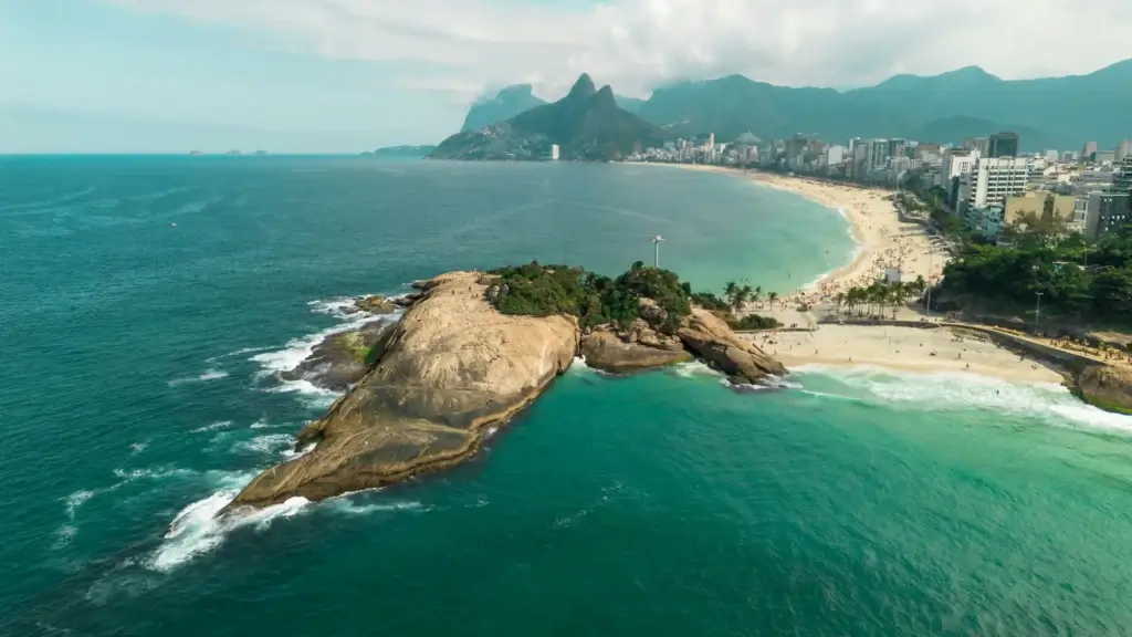 Aerial view of Arpoador beach, focusing on its famous rock formation.