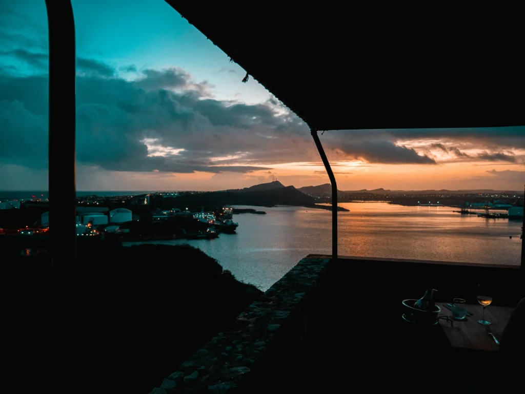 Foto de cena romántica nocturna en Curazao con vista al mar.