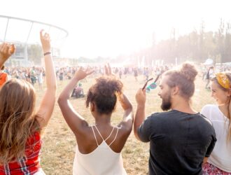 Vários jovens dançando e se divertindo em um festival de música.